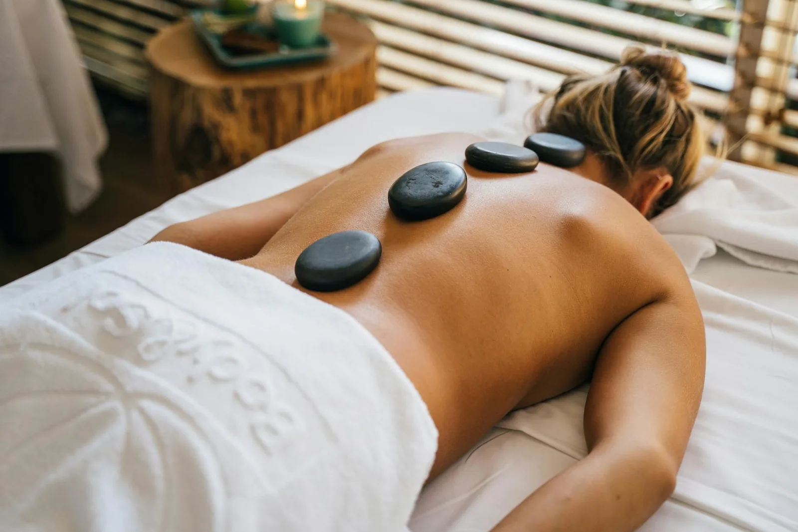 Smooth basalt stones placed along the back during a hot stone massage session.