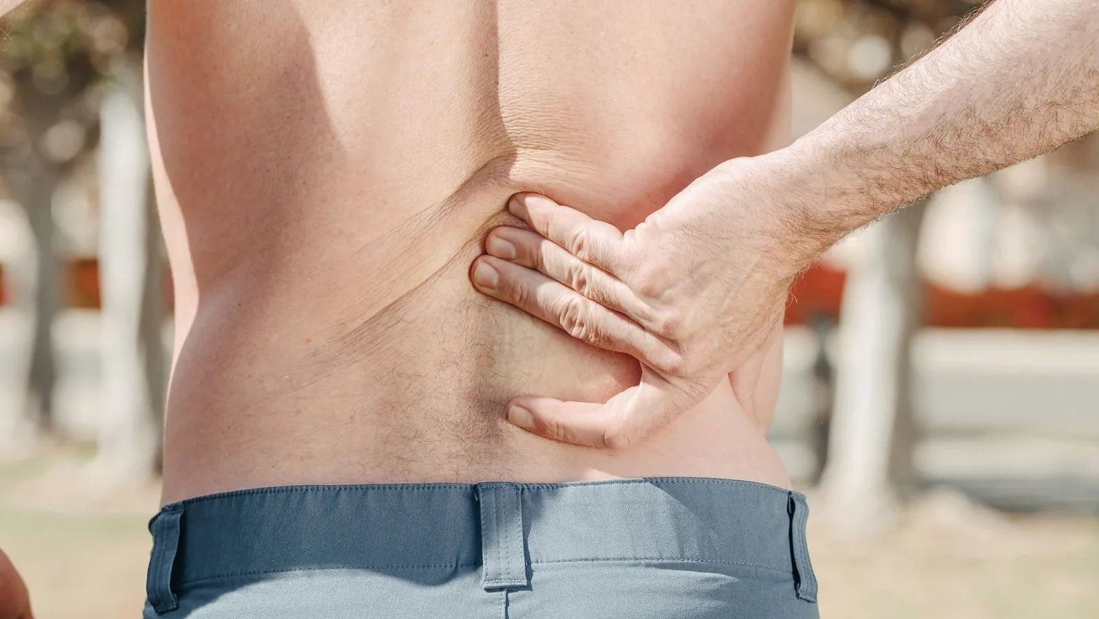 Man holding his lower back with one hand