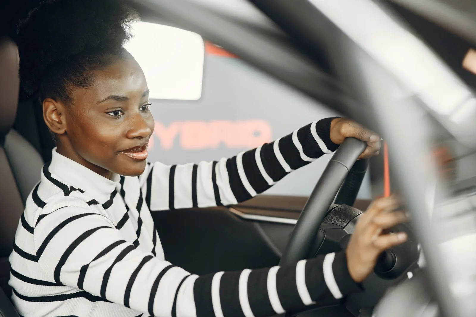 Woman in a striped top at the wheel of a car